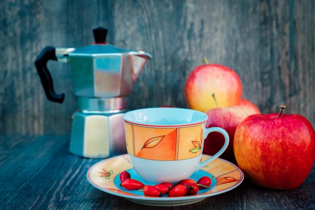 Una taza de té rosa caderas manzanas y un hervidor vitaminas prevención de enfermedades