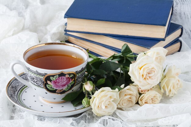 Taza de té con rosa en la mesa de madera blanca