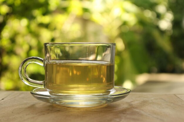 Una taza de té sobre un fondo borroso de la naturaleza