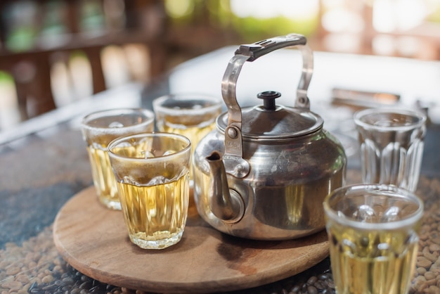 Taza de té y tetera en la mesa, fondo natural