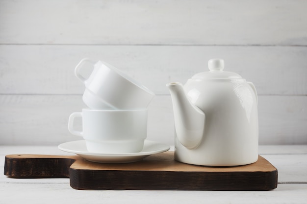 Taza de té, tetera, tabla para cortar roble en blanco