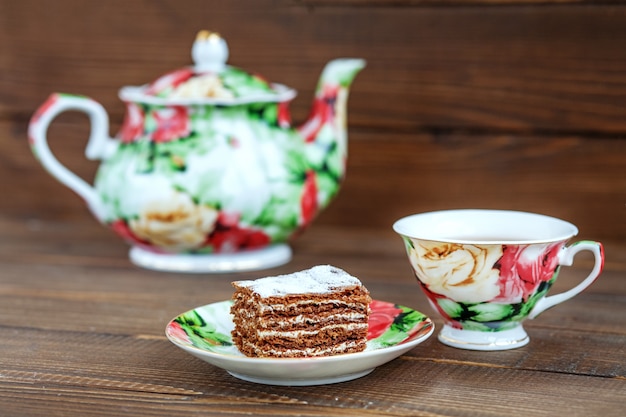 Taza de té y torta en un fondo de madera.