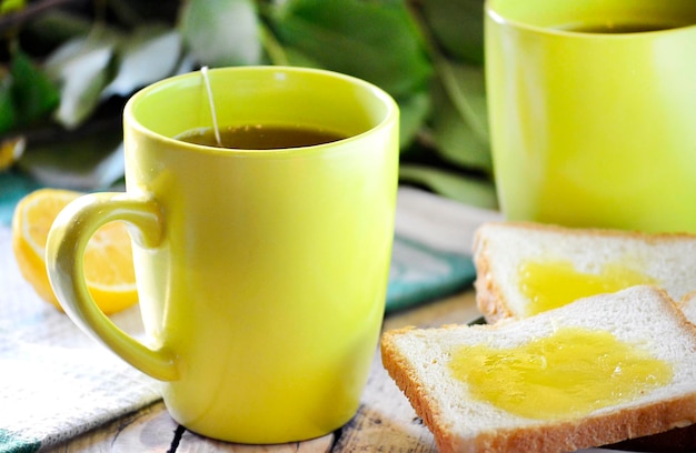 Taza de té y tostadas frescas con miel y limón.