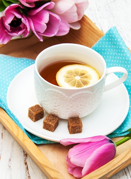 Taza de té y tulipanes rosados