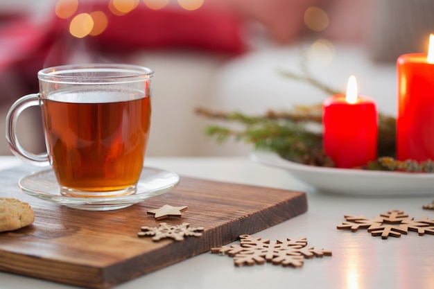 Taza de té con velas encendidas en casa