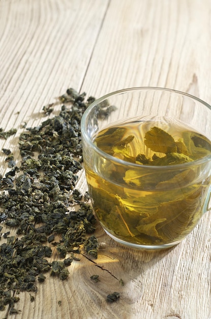 Taza de té verde con hojas secas