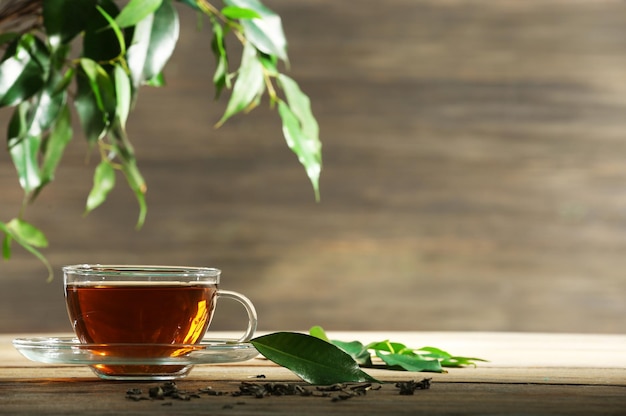 Taza de té verde en la mesa sobre fondo de madera