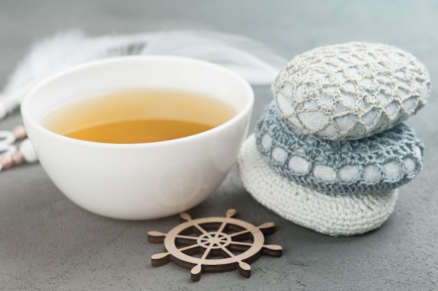 Taza de té verde y piedras de ganchillo