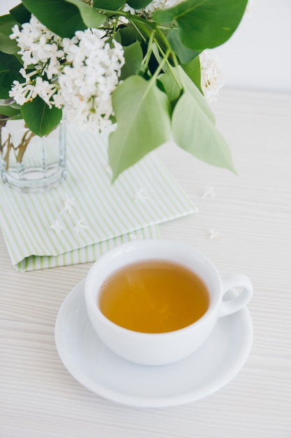 Taza de té verde sobre una mesa blanca