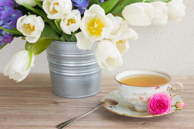 Foto taza de té vyntage con tulipanes blancos