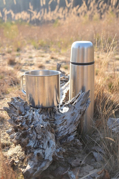 Una taza y un termo están en el suelo.