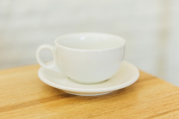 Taza vacía blanca en mesa de madera en un restaurante