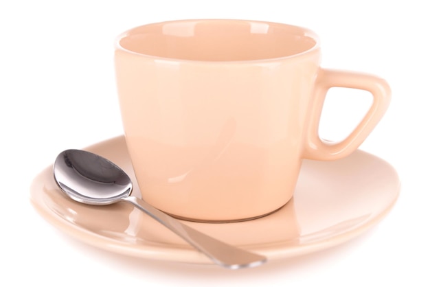 Taza vacía con cuchara de té aislado en blanco