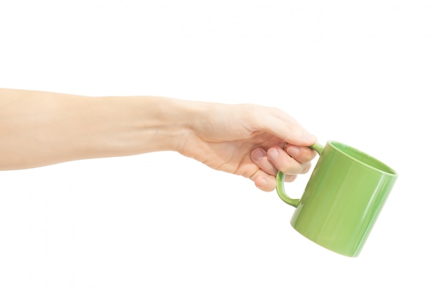 Una taza verde en la mano aislada