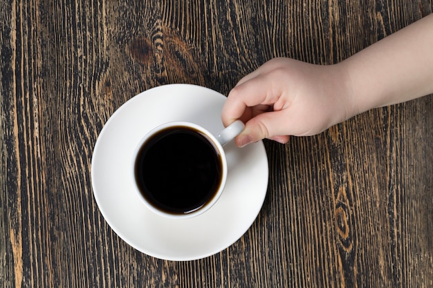 Taza de vidrio blanco con delicioso café aromático negro vertido en él