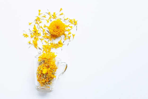 Una taza de vidrio con pétalos de flores de caléndula. Concepto de té de hierbas de flores.