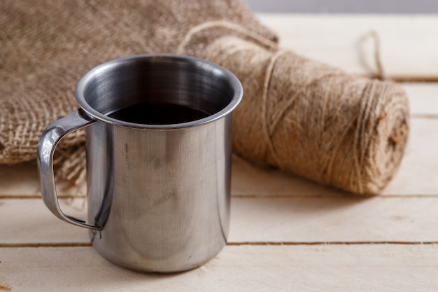 Taza vintage de hierro con té en la mesa de madera. maraña de hilos