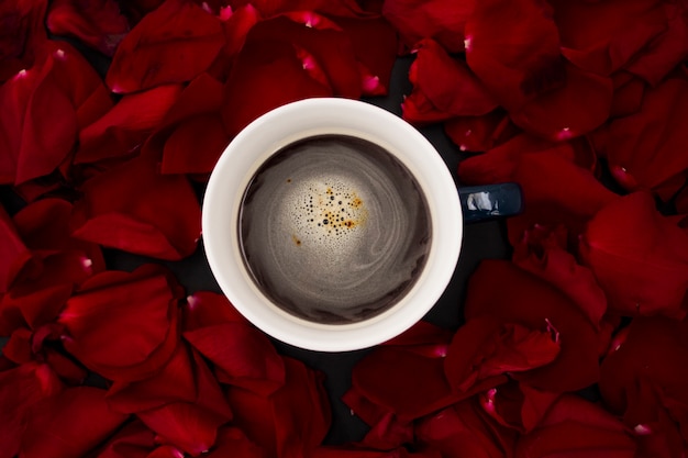 Taza con vista superior de café con pétalos de rosa