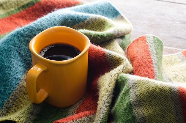 Tazas de café y bufandas en una mesa de madera