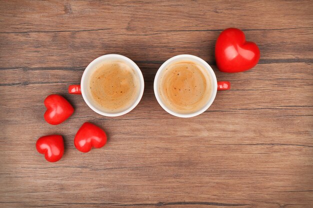 Tazas de café con corazones en la mesa de madera