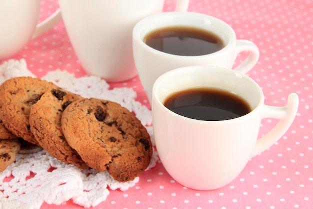 Tazas de café con galletas en primer plano de servilleta rosa