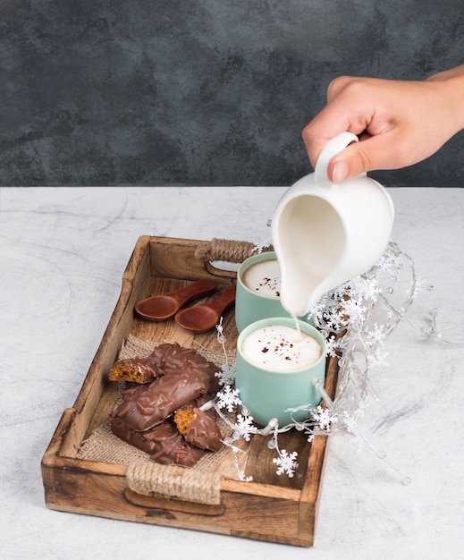 Tazas de café con leche y pan de jengibre recubierto de chocolate en una cesta de madera, espacio de copia vacío