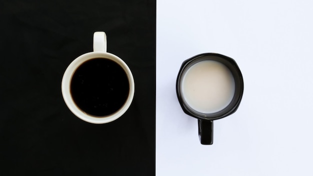 Tazas de café y leche sobre fondo blanco y negro