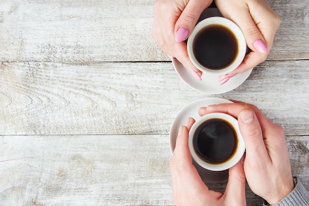 Tazas con café en manos de hombres y mujeres. Enfoque selectivo. Beber.