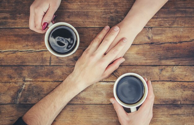 Tazas con un café en manos de hombres y mujeres. Enfoque selectivo