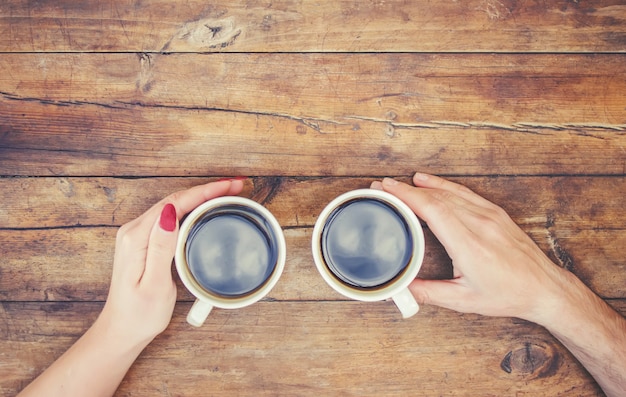 Tazas con un café en manos de hombres y mujeres. Enfoque selectivo