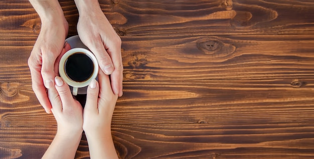 Tazas con un café en manos de hombres y mujeres.