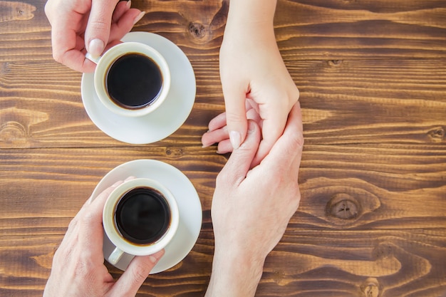 Tazas con un café en manos de hombres y mujeres.