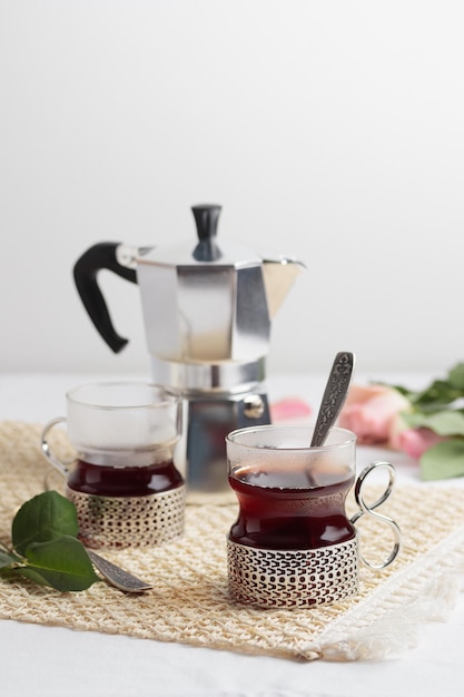 Tazas de café recién hecho y cafetera en mesa blanca