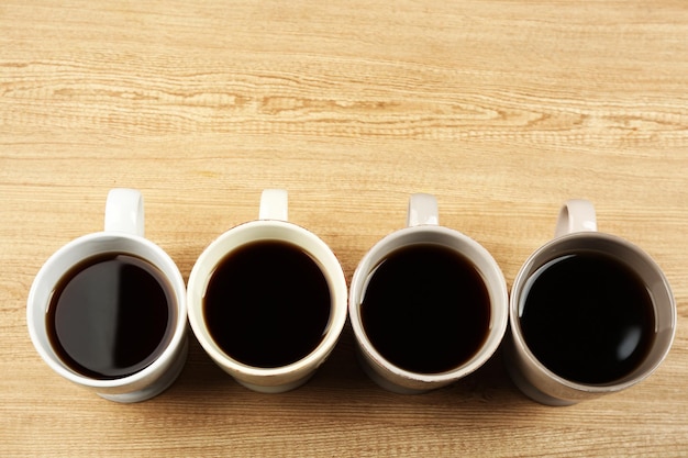 Tazas de café sobre fondo de mesa de madera