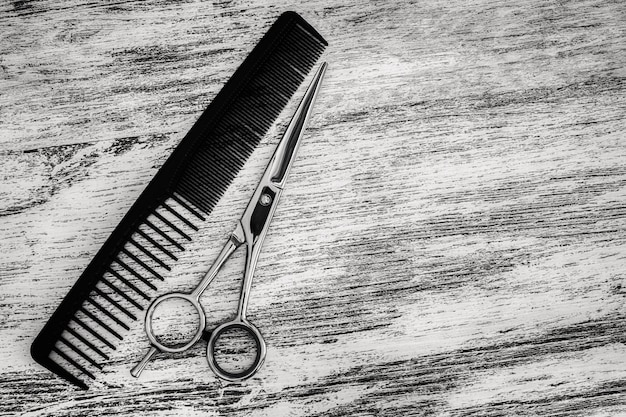 Tazas para cortar el cabello para peluqueros y peine en salón de belleza sobre fondo de madera
