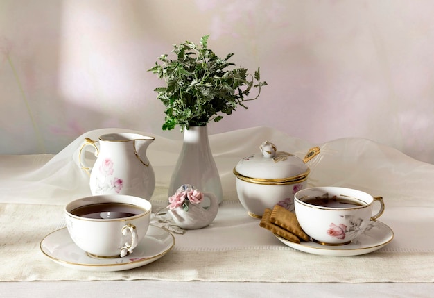 Tazas con galletas de té y un ramo en el primer plano de la mesa