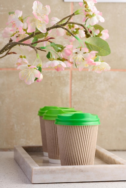 Tazas marrones de papel con tapa verde de plástico para café y té