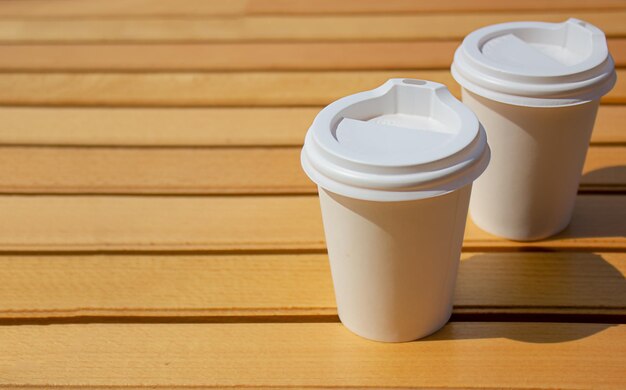 Tazas de papel con café sobre un fondo de madera Concepto de comida callejera Espacio de copia