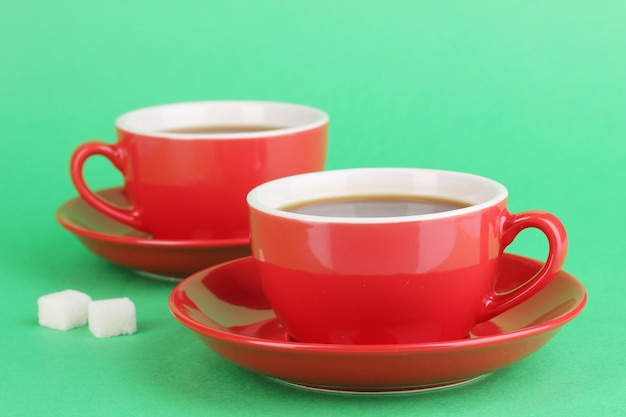 Tazas rojas de café fuerte sobre fondo verde