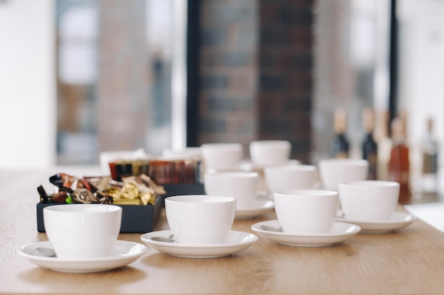 Tazas de té blanco con platillo de pie sobre la mesa