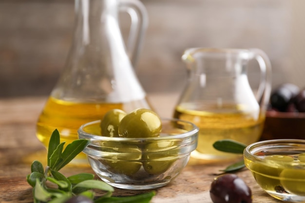 Tazón con aceitunas saludables en la mesa de madera