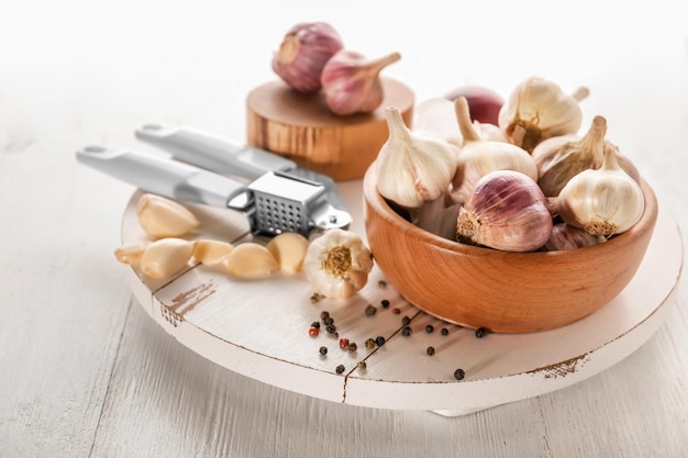 Tazón con ajo fresco en tablero de madera