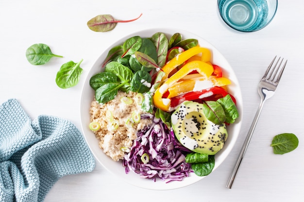 Tazón de almuerzo de cuscús vegetariano con aguacate, pimientos, espinacas y repollo rojo