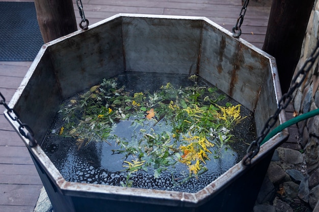 Tazón de baño grande con agua y flores en el exterior. Relajación y terapia.