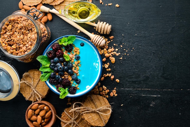 Tazón de batido de espirulina azul y frutas frescas Cubierto con moras, arándanos, granola y yogur Desayuno Vista superior Espacio libre para el texto