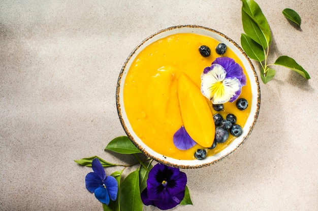 Tazón de batido Lassi de mango con cúrcuma Fruta tropical fresca sobre un fondo claro Comida saludable