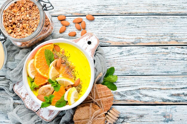 Tazón de batido con naranja, plátano, limón y almendras Desayuno Vista superior Espacio libre para su texto