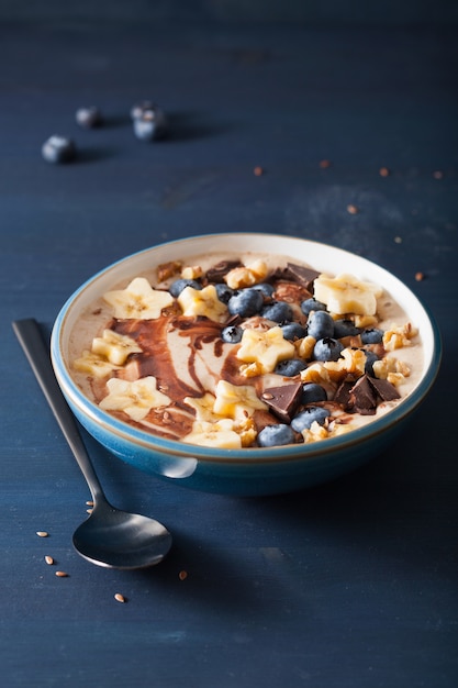 Tazón de batido de plátano saludable con nueces de chocolate con arándanos