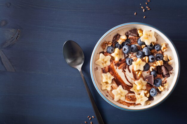 Tazón de batido de plátano saludable con nueces de chocolate con arándanos