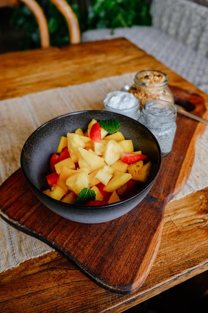 Foto un tazón de batido saludable de piña y mango con yogur de coco, semillas de chía y granola